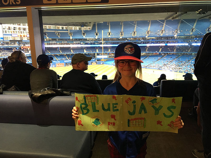 Picture of a young girl holding a Blue Jays sign