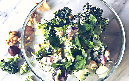 A transparent bowl with Broccoli, Grape, Walnut