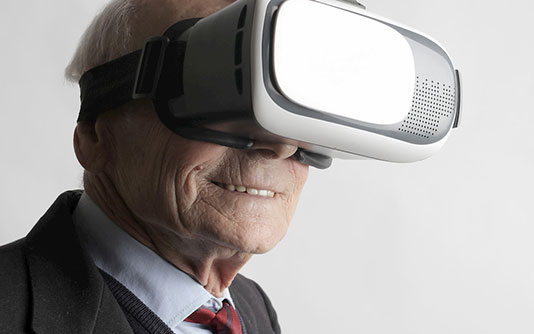 An older man wearing a VR glasses