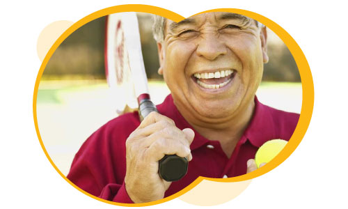 A happy older man holding a tennis racket