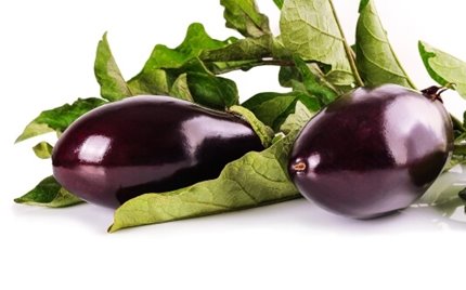 Two eggplants with some leaves on a white background